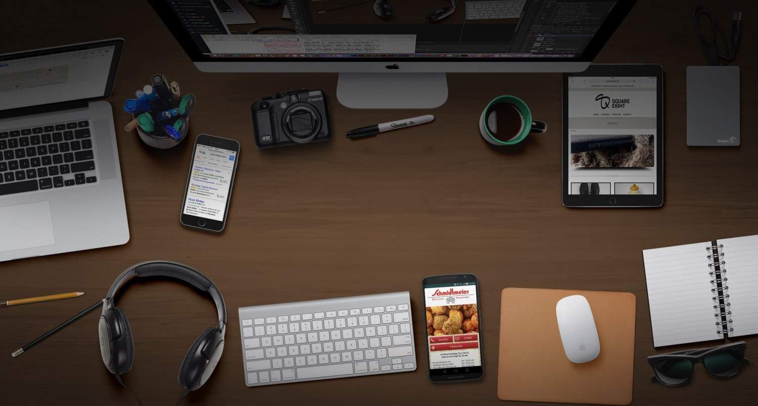 Arbeitsplatz für Webdesign und SEO mit Computer, Laptop, Tablet und Smartphones